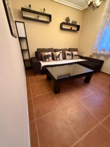 ein Wohnzimmer mit Sofa und Tisch in der Unterkunft Cuencaloft Relax en familia con barbacoa in Chillarón de Cuenca + 25 Fotos