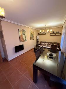 ein Wohnzimmer mit Tisch und Couch in der Unterkunft Cuencaloft Relax en familia con barbacoa in Chillarón de Cuenca