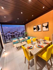 a dining room with a table and yellow chairs at Bensahome CaboNegro in Cabo Negro
