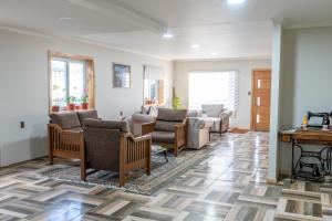 a living room with couches and chairs and a piano at Hostal Andes Patagónicos in Puerto Natales