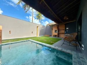 a swimming pool in the backyard of a house at Bangalô Miramar Maragogi in Maragogi