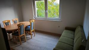 Gädheimにある3 Zimmer Ferienwohnungのテーブルと椅子とソファのあるリビングルーム