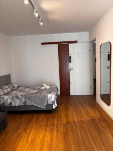 a bedroom with a bed and a mirror in it at 100 m da Praia do Forte com AR e Wi Fi. in Škorak