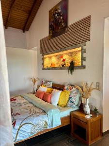 ein Schlafzimmer mit einem Bett mit bunten Kissen in der Unterkunft Villa Iséa - Piscine privée & Terrasse Vue Mer in Le Gosier