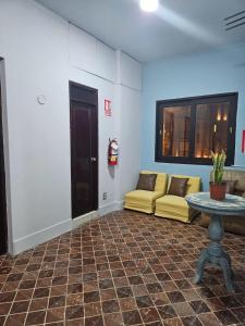 a living room with a yellow couch and a table at Haku Hostel in Lima