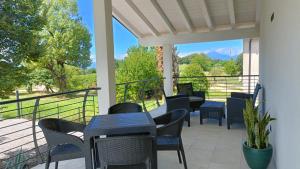 a porch with tables and chairs and a view at APPARTAMENTO " Le Terre del Garda " in Castelnuovo del Garda
