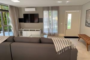 a living room with a couch and a table at Alto Padrão 5 Stes +1 apoio Piscina quente+Jacuzzi in Praia Guaratuba