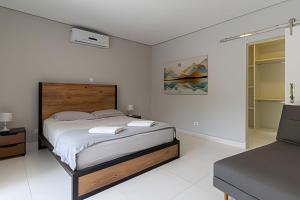 a white bedroom with a large bed in it at Alto Padrão 5 Stes +1 apoio Piscina quente+Jacuzzi in Praia Guaratuba +51 photos