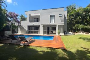 a house with a swimming pool in front of a yard at Alto Padrão 5 Stes +1 apoio Piscina quente+Jacuzzi in Praia Guaratuba
