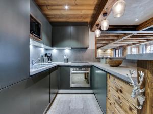 a kitchen with gray cabinets and a sink at Arc 1950: Apt 10 pers, 4 ch, ski pieds, wellness, wifi - FR-1-686-44 in Arc 1950