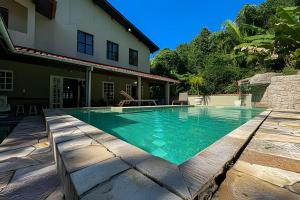 a swimming pool in front of a house at Fantastica casa proxima do mar! in Praia Guaratuba