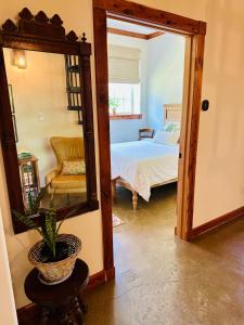 ein Zimmer mit einem Schlafzimmer mit einem Bett und einem Spiegel in der Unterkunft Whispering Pines Retreat, Secluded Cabin with Hot Tub & Pond in Jacksonville + 24 Fotos