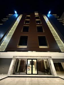 a tall building with glass doors at night at The Square One in Jeddah