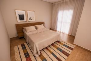 a bedroom with a bed and a rug at @Stay22 - Sítio Ypê Amarelo /Alto padrão - Luxuoso in São Lourenço +109 photos