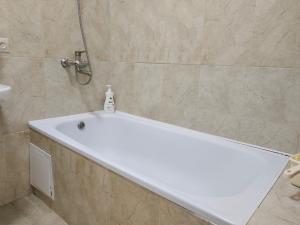 a white bath tub in a bathroom with a shower at Светлая теплая двухкомнатная квартира на Юго-Востоке in Karagandy