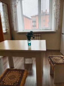 a table with a vase of flowers on it in front of a window at Светлая теплая двухкомнатная квартира на Юго-Востоке in Karagandy +6 photos