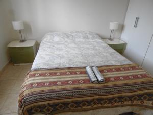 un lit dans une chambre avec deux tables de nuit et deux lampes dans l'établissement Departamento Gaviota I, à Posadas