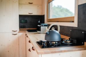 a tea kettle sitting on top of a stove in a kitchen at Glamping Meze Samota 30min od Brna in Slavkov u Brna