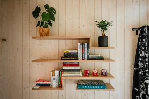 a wall with wooden shelves with books and a potted plant at Glamping Meze in Golčŭv Jeníkov