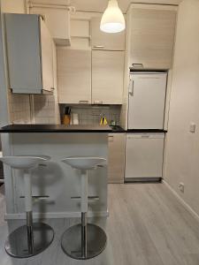 eine Küche mit Theke und zwei Barhockern in der Unterkunft Cozy Studio in Turku, Accommodation for Four in Turku