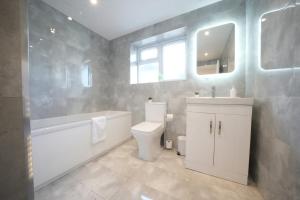 a bathroom with a toilet and a tub and a sink at Near Heathrow Airport -FREE Parking-Full apartments-Near M4-1 bus LHR in Stanwell