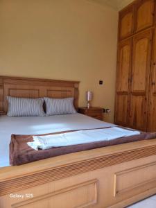 a bedroom with a large bed with a wooden headboard at Leila in Agadir