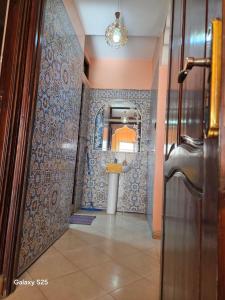 a hallway with a bathroom with a sink and a mirror at Leila in Agadir +26 photos