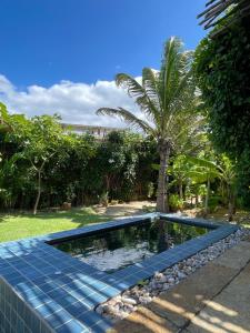 a swimming pool with a palm tree in a yard at KOA Loft - Praia de Moitas in Amontada