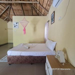 - une chambre avec un lit avec un cerf-volant sur le mur dans l'établissement Resort Mikaju, à Marracuene