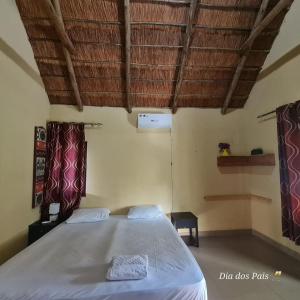 une chambre avec un grand lit dans une pièce dans l'établissement Resort Mikaju, à Marracuene