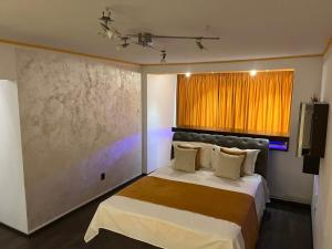 a bedroom with a large bed with an orange curtain at Apartament Horatio in Galaţi