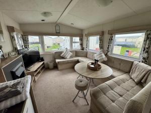 a living room with a couch and a table at TheLeoHome in Selsey
