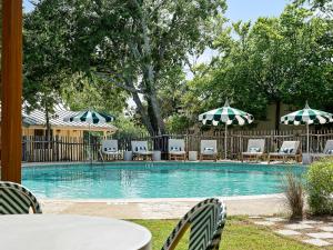 a pool with chairs and tables and umbrellas at The Meyer Hotel in Comfort