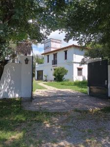 a white house with a fence in front of it at La Fonda de Jorge in Rosario de Lerma