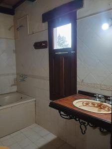 a bathroom with a sink and a tub and a window at La Fonda de Jorge in Rosario de Lerma