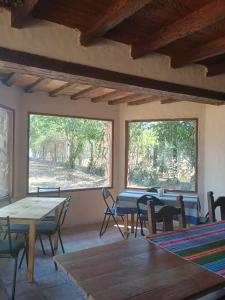 a room with tables and chairs and two windows at La Fonda de Jorge in Rosario de Lerma