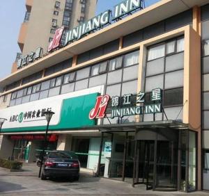 ein Gebäude mit einem davor geparkt in der Unterkunft Jinjiang Inn - Wuxi Wangzhuang Road in Wuxi