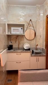 eine Küche mit Spüle und Mikrowelle in der Unterkunft Ste. 6 Premium na quadra da Praia do Forte in Škorak