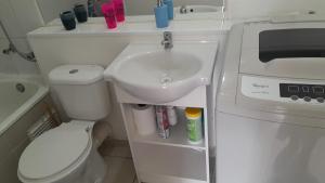 a small bathroom with a sink and a toilet at Departamento 610 in Temuco +23 photos