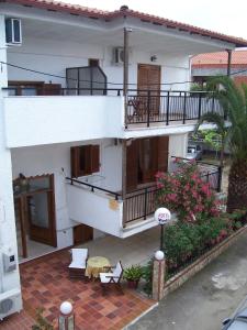 a white house with a balcony and a patio at Vanta Hotel in Limenas
