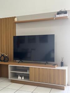 a large entertainment center with a large screen television at Casa Compartilhada - Refúgio Urbano in Garanhuns