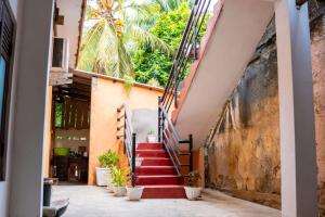 Una escalera en un edificio con escaleras rojas y plantas. en Aananda Vasam, en Jaffna