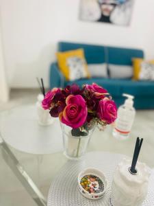 una mesa con un jarrón de flores y un tazón de dulces en Zappalà Fortino House 2, en Catania