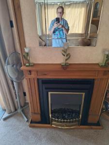 una mujer tomando una foto de una chimenea con un espejo en TF1 Static, en Aberystwyth