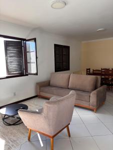 a living room with a couch and a chair at Casa no Foguete com piscina in Škorak