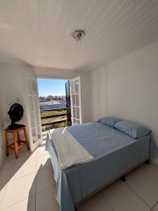 a bedroom with a bed and a large window at Casa no Foguete com piscina in Škorak