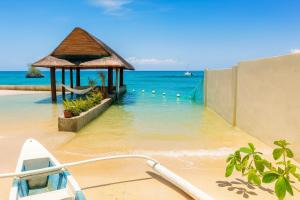 a boat on a beach with a gazebo in the water at On-the-beach JADE's BEACH VILLA 별장 Lapu-lapu Olango 별장 in Lapu Lapu City