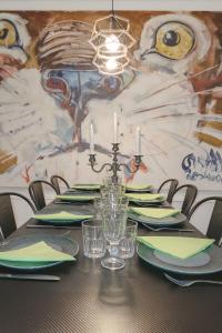 a table with green plates and candles in front of a mural at Le Lodge Arthur Appartement 8 personnes in Barraux