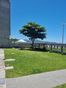 a park with a tree and an umbrella at Duplex Pé na Areia - 3 Quartos - Vista para o Mar - Até 08 Pessoas in Itapema