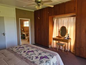 une chambre avec un lit avec une commode et un miroir dans l'établissement Nawi Unit 3, à Potchefstroom